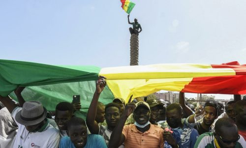 Protestors hold a giant flag of the Senegal as they attend a rally of the Senegalese opposition at the Place de l'Obelisque in Dakar, on June 8, 2022. - Senegal's main opposition leader Ousmane Sonko said on June 7, 2022 he was determined to defy a possible ban on demonstrations on June 8, 2022 with his supporters against the rejection of his list for the upcoming legislative elections. (Photo by SEYLLOU / AFP)